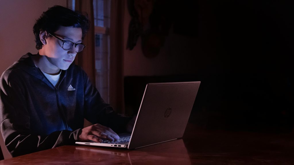 Man looking at laptop in dark